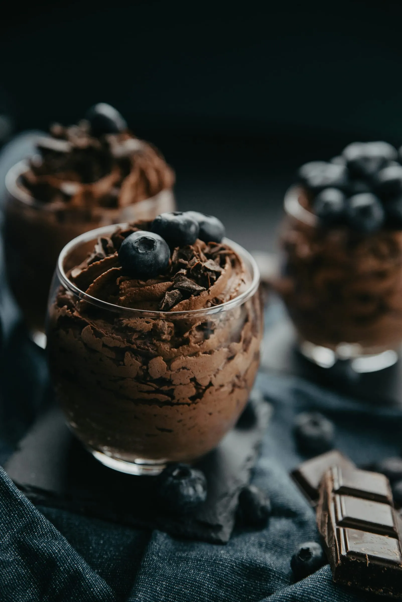 Chocolademousse in glazen, afgewerkt met blauwe bessen en stukjes pure chocolade